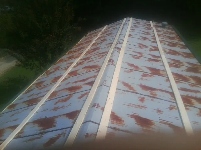 Rusted metal roof panels with new wood purlins before replacement — Storm Damage Roof Repair in Herndon by Roofing Brothers