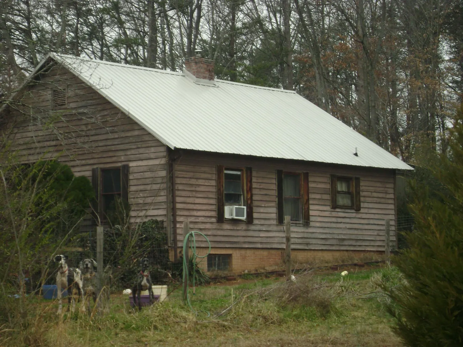 White metal roof on an old wood sided farmhouse, from a Metal Roof Installation job in Herndon